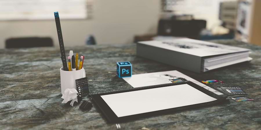An orderly office desk with some pens and a binder