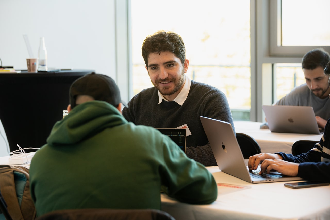 Engineers in conversation during a break, with a lot of laptops open