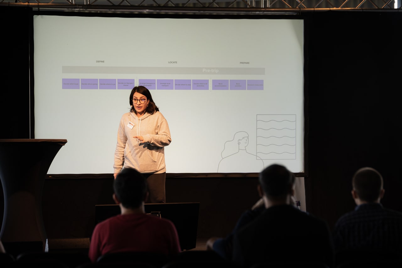 Nayyereh Afzali on stage, speaking about the "Job to be Done" framework as used in trivago